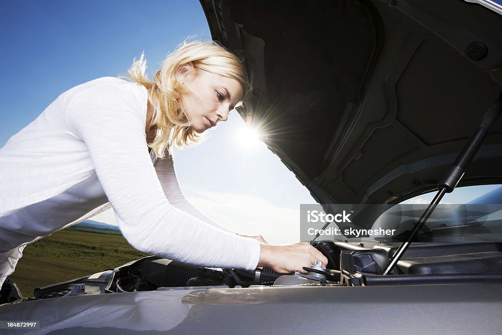 Giovane donna preoccupato perché la sua auto rotto il basso. - Foto stock royalty-free di Aperto
