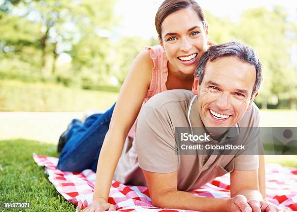 Foto de Casal Fazendo Um Piquenique e mais fotos de stock de Homens Maduros - Homens Maduros, Mulheres Jovens, Exterior