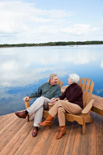 istock Senior couple sitting by water 184873112