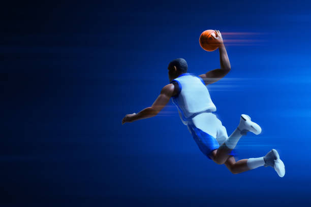 istock 3d illustration young professional basketball player slam dunk on dark blue background 1848732740