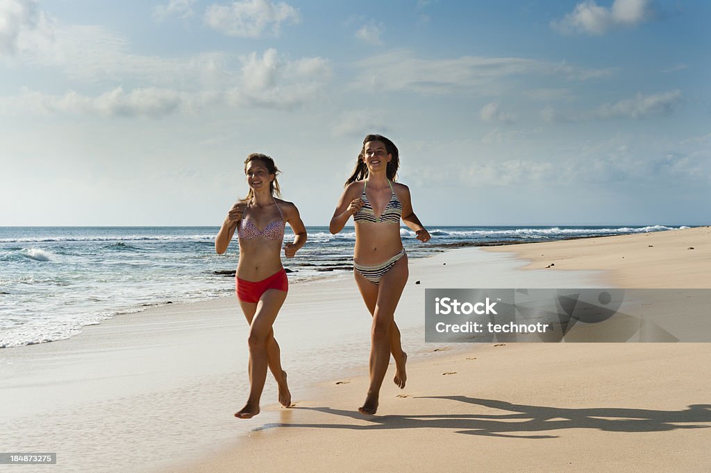 Adolescentes a trotar en la playa - Foto de stock de Actividad física libre de derechos