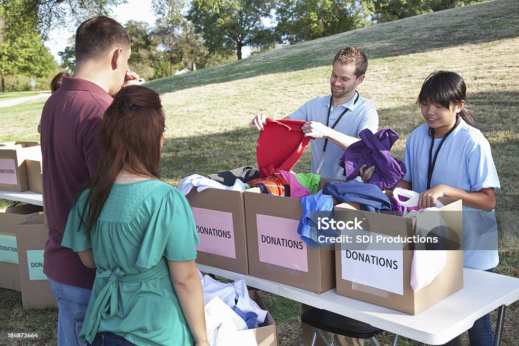 Voluntários receber doações de roupas de dadores em uma doação center - Foto de stock de Adulto royalty-free