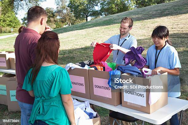 Doações De Voluntários Com Roupas Dadores Em Um Centro De Doação - Fotografias de stock e mais imagens de Adulto