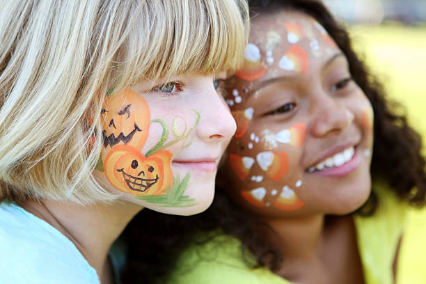Two children with Halloween scenes painted on their faces face painted kids halloween face paint stock pictures, royalty-free photos & images