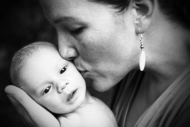 Beautiful Mom Kissing Newborn stock photo