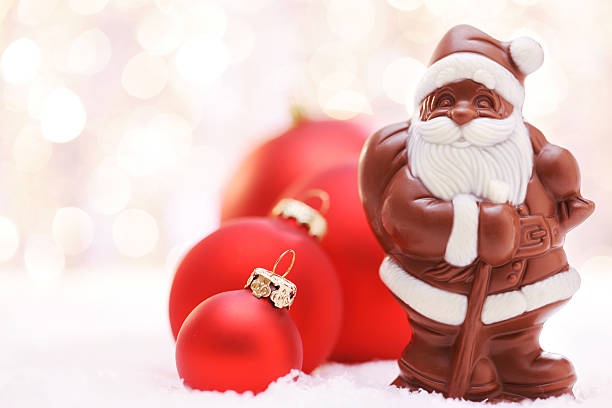 Chocolate Santa and Red baubles Chocolate Santa and Red baubles - shallow dof - XXXL Image fake snow stock pictures, royalty-free photos & images