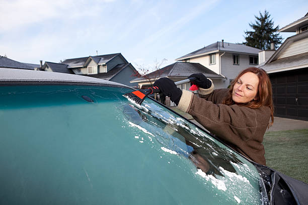istock Woman scraping frost off her van's windscreen. 184874632