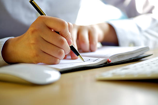istock Man in white shirt writing a document with a pen 184874893