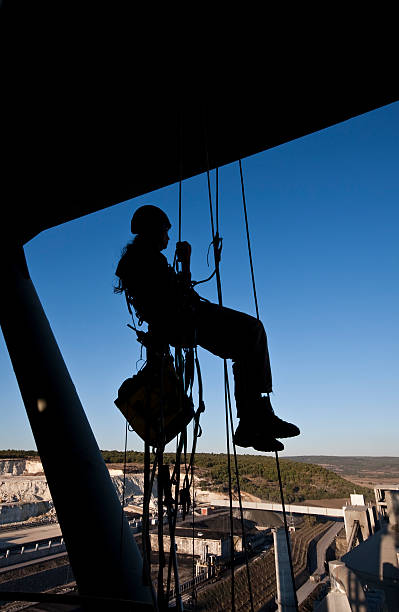 istock Female construction worker on ropes and pulleys high above 184875693