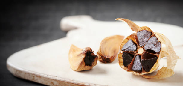 istock Black garlic on old wooden board 1848757228