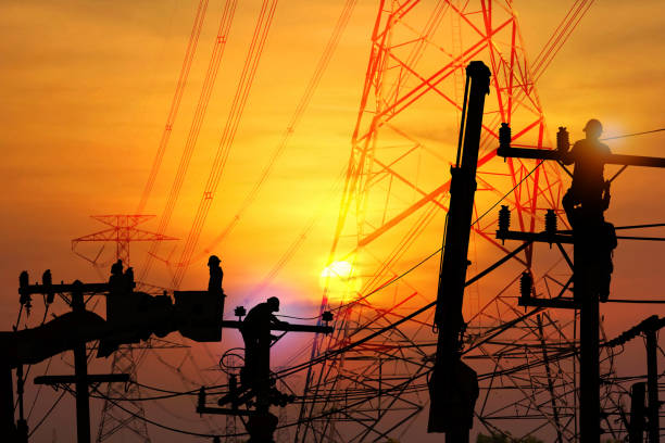istock group of silhouette electric worker working on pole connected high voltage transmission line with  high volttag transmission towers 1848758254