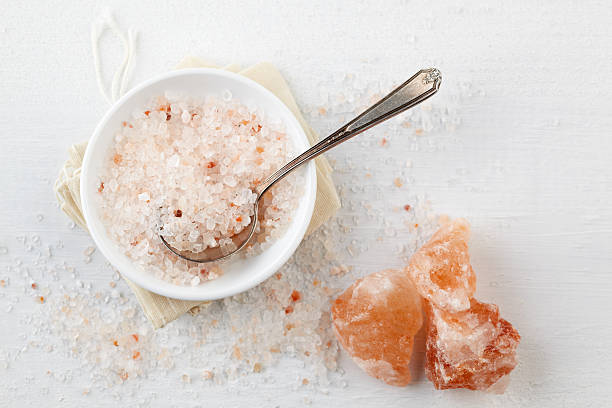 Himalayan Pink Rock Salt in bowl on table "Himalayan Pink Rock Salt in bowl on table, can be used in food or in bathtub" bath salt photos stock pictures, royalty-free photos & images