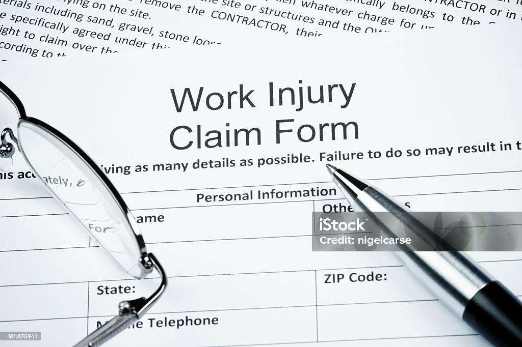 Blank work injury claim form with guidelines Work Injury Claim Form with spectacles and ballpoint pen Physical Injury Stock Photo