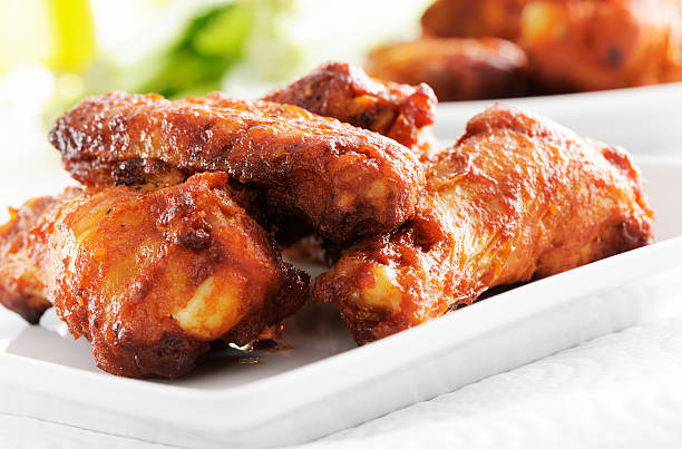 Spicy chicken wings in a white plate, on a white background