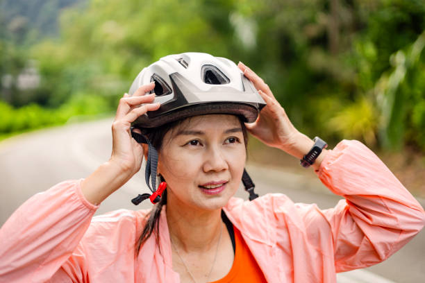 istock Female Cyclist Putting on Helmet Before Workout 1848768554