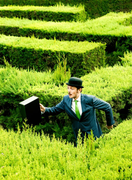 istock Man wearing a suit running in hedge maze 184876940