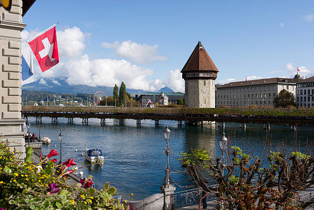 World famous landmark Chapel Bridge and Water Tower at Swiss city of Luzern on a sunny summer day. Photo taken August 25th, 2025, Lucerne, Switzerland.