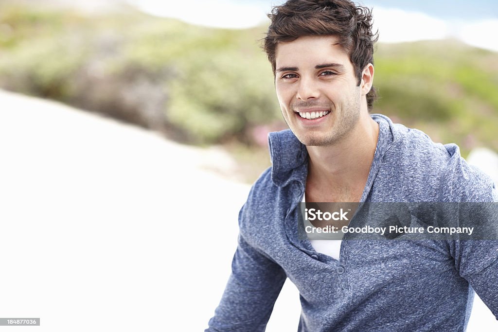 Uomo sorridente rilassante all'aperto - Foto stock royalty-free di Abbigliamento casual