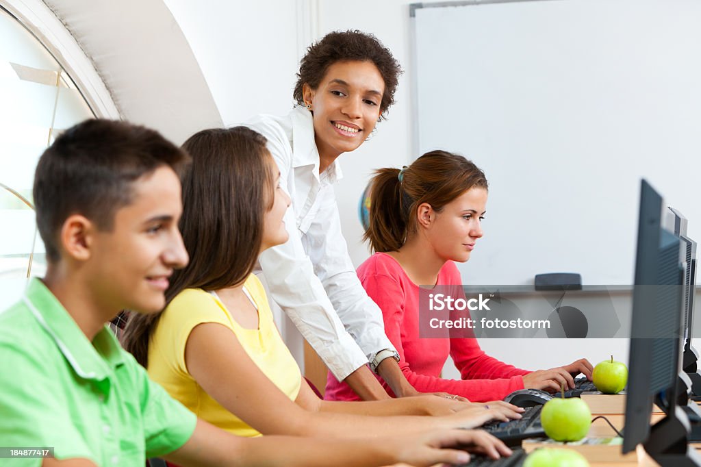 Professor com os alunos trabalhando em computadores na sala de aula - Royalty-free Professor Foto de stock