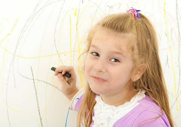 Petite fille est la peinture sur le mur - Photo