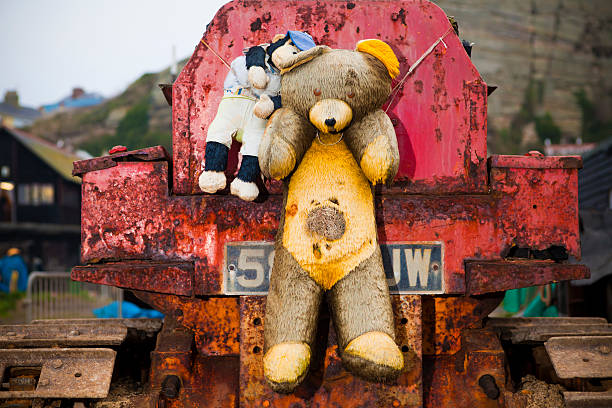 Dirty old teddy bear on the back of a bright boat.