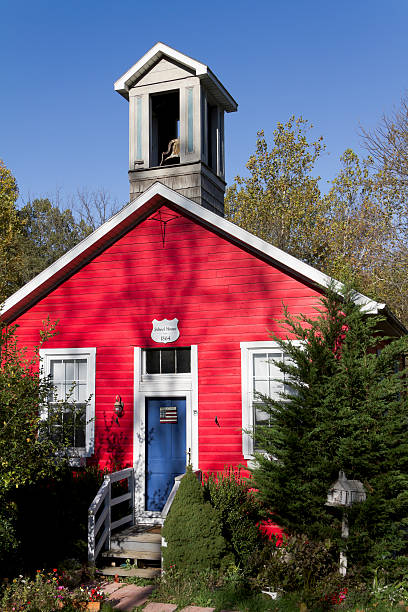 An old red one room school house with a bell tower on top.  The bell was used to signal the start and end of the school day.