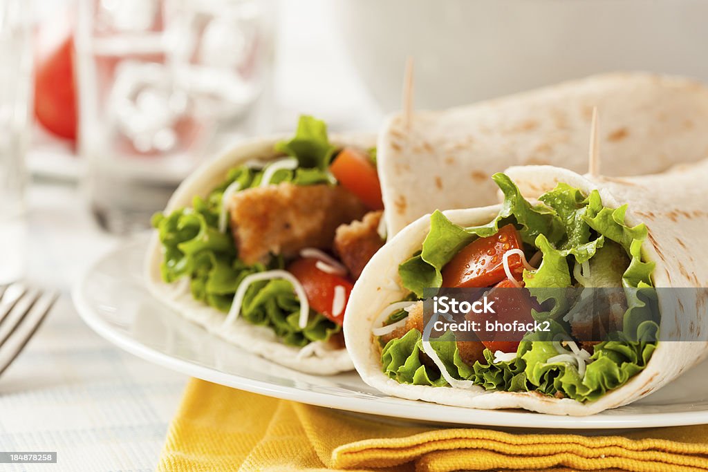 Breaded Chicken in a Tortilla Wrap Breaded Chicken in a Tortilla Wrap with Lettuce and Tomato Appetizer Stock Photo