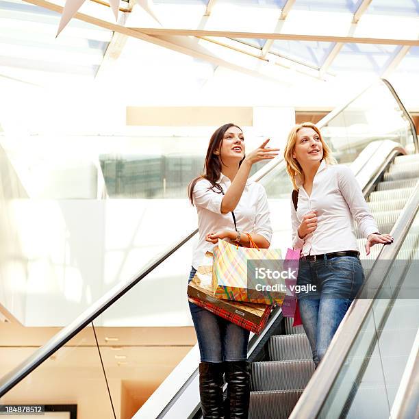 Amigos De Duas Mulheres Tomar Escada Rolante Em Shopping Mall - Fotografias de stock e mais imagens de 20-24 Anos