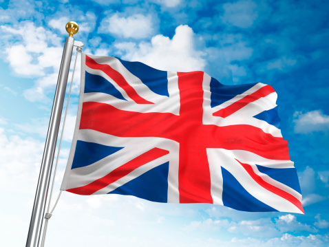 Waving United Kingdom flag against cloudy sky. High resolution 3D render.
