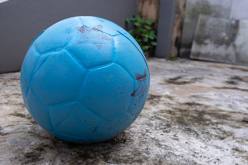A Football blue and color with plastic material in the front house a with cement floor Background
