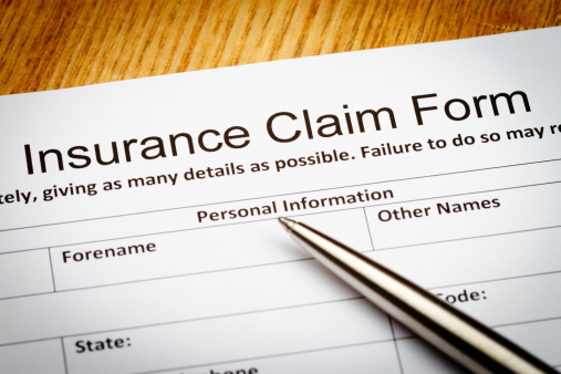 An Insurance Claim Form on a desk with Ballpoint pen.