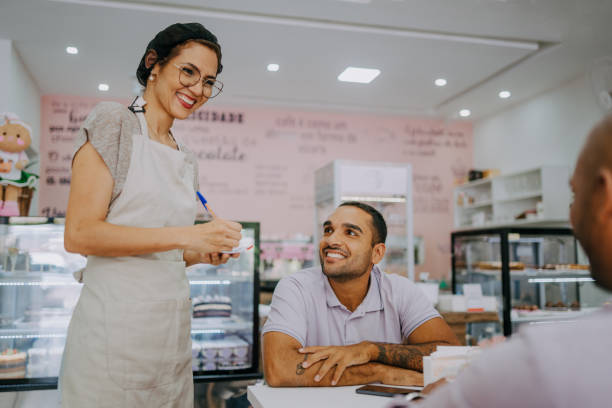 Woman taking customer order in cafe