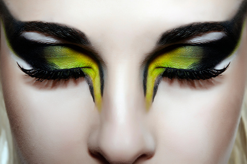 green with yellow makeup ; woman with eyes closed.