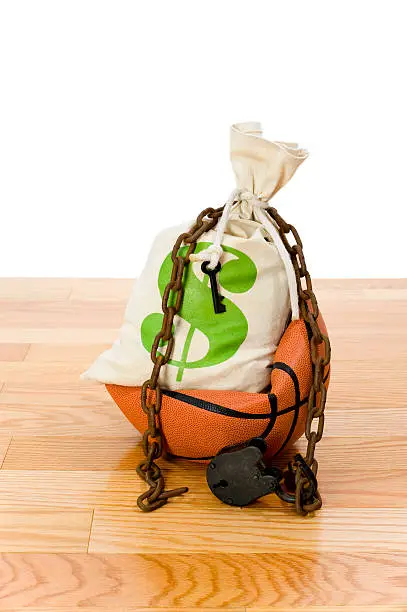 Concept-NBA Lockout. Basketball sitting on hardwood court with a money bag, chain and padlock