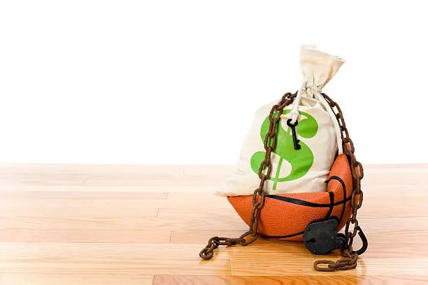 Concept-NBA Lockout. Basketball sitting on hardwood court with a money bag,  chain and padlock