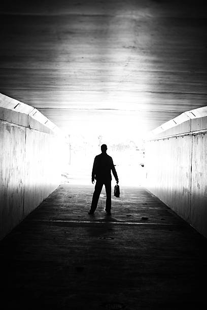istock Lone businessman walking through tunnel with briefcase 184881041