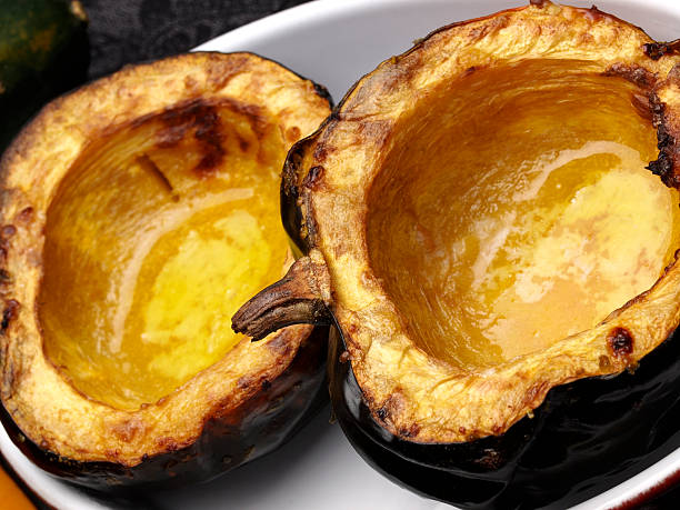 Acorn Squash Roasted Freshly Split and Roasted Acorn (or Danish) Squash with butter. acorn squash stock pictures, royalty-free photos & images