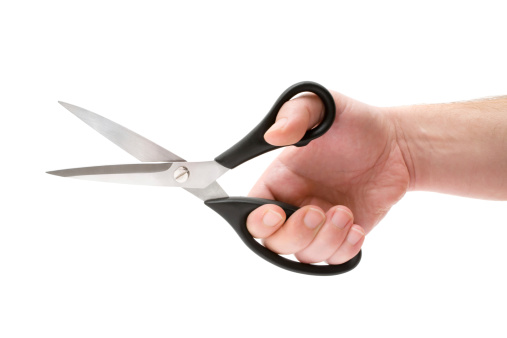 Male hand holding a pair of scissors. Isolated on a white background.