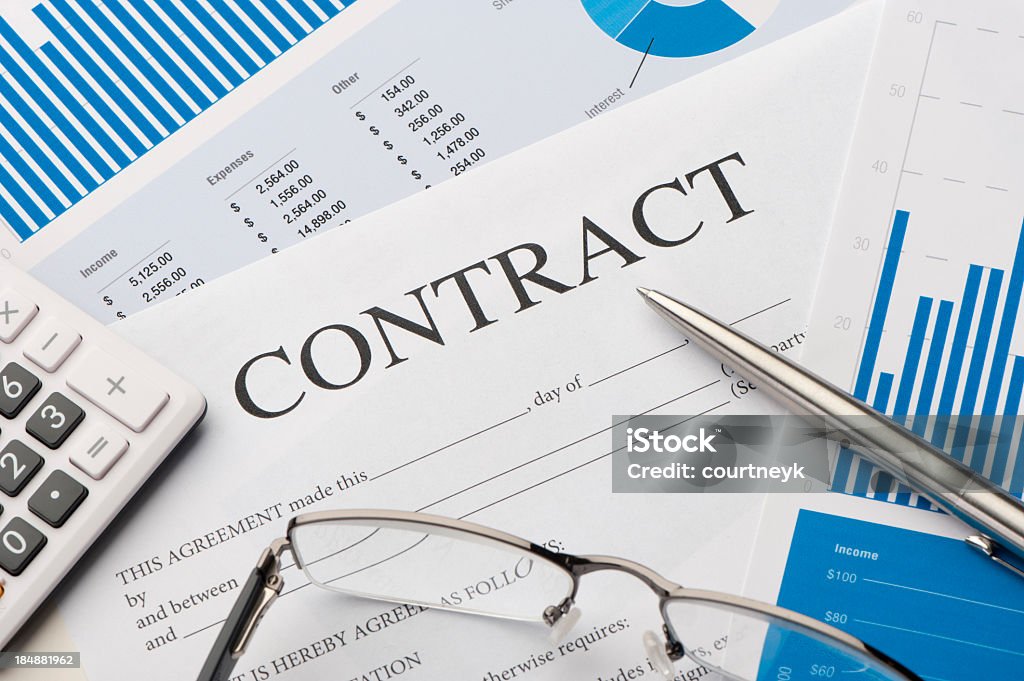 Close-up image of contract form on a desk Contract form on a desk with pen, calculator and glasses Contract Stock Photo