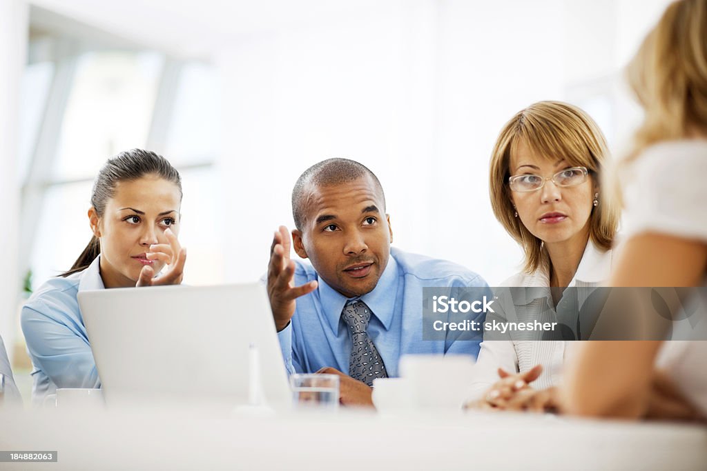 Businesspeople working on laptop in an office. Smiling group of successful businesspeople on a meeting. Businessman Stock Photo