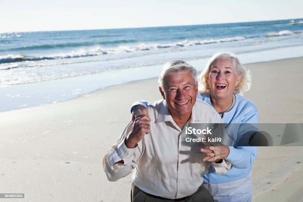 couple Senior rire sur la plage - Photo de 65-69 ans libre de droits