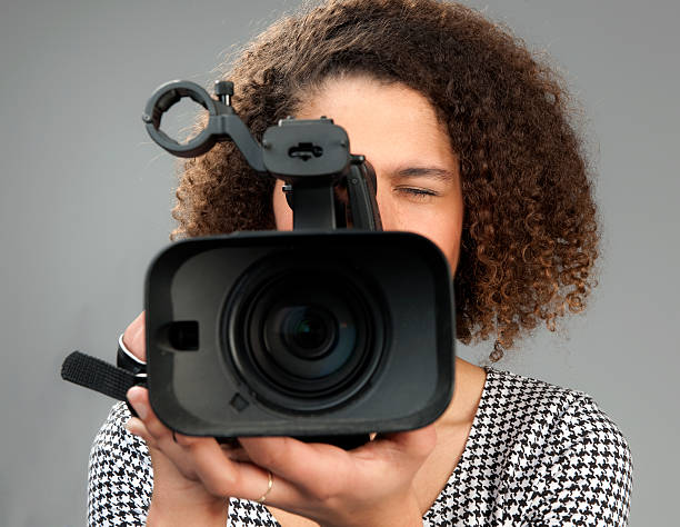 istock young woman filming with video camera 184882471