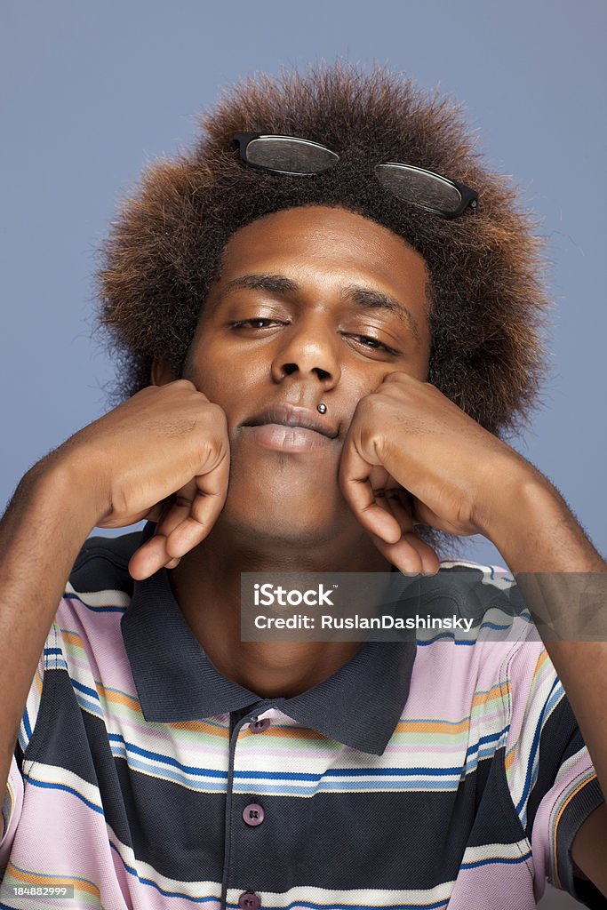 Teenage boy with head in hands. Portrait of African teenager boy sits having propped up with head on hands. Funky Stock Photo