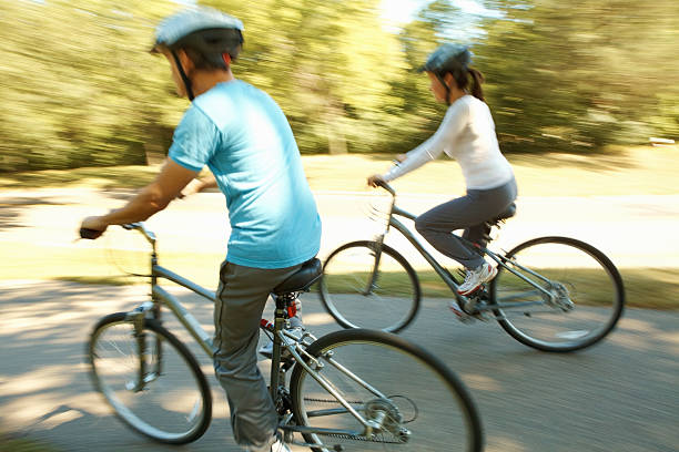 istock Man and woman cycling together 184884200