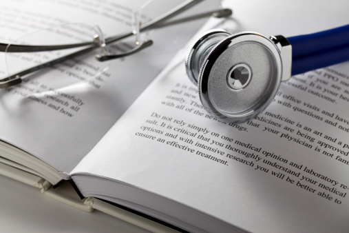 Stethoscope and glasses on book. Concept for medical research. Get second opinion.