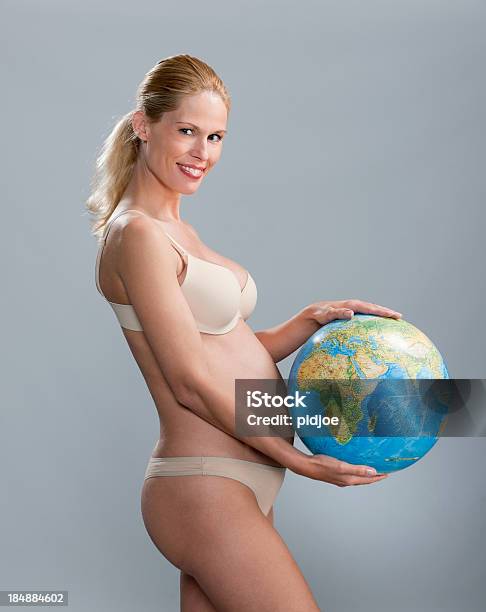 Embarazada Rubia Sonriente Mujer Holding Mundo Foto de stock y más banco de imágenes de Mujeres - Mujeres, Una sola mujer, Agarrar