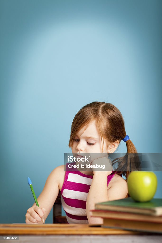 Молодой студент, сидя на столе делает работу с местом для копии - Стоковые фото Ребёнок роялти-фри