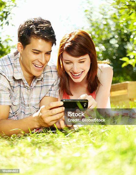 携帯電話を使用する美しいカップルの - 20代のストックフォトや画像を多数ご用意 - 20代, 2人, くつろぐ