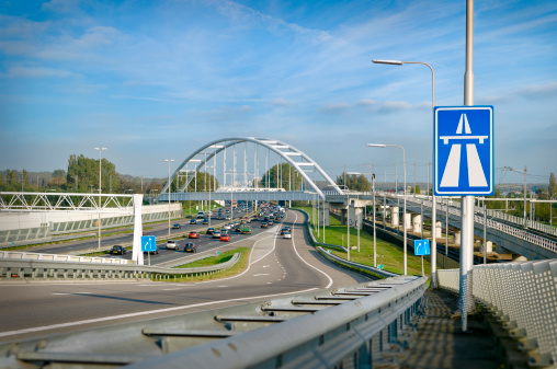Entrance ramp to the freeway 'A12' near The Hague, Holland. Traffic drives underneath a railwaybridge.