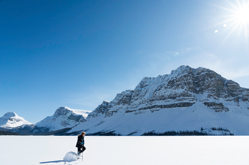 Snowshoeing across a snowy lake off the Columbia Icefields Parkway between Lake Louise and Jasper, Albera, Canada